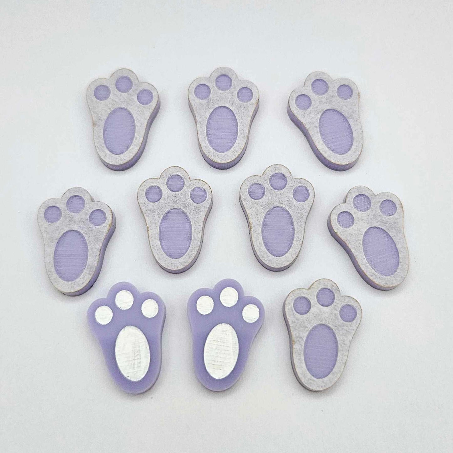 Pastel purple bunny paw print stud blanks showing two paint filled white and several unpainted pieces