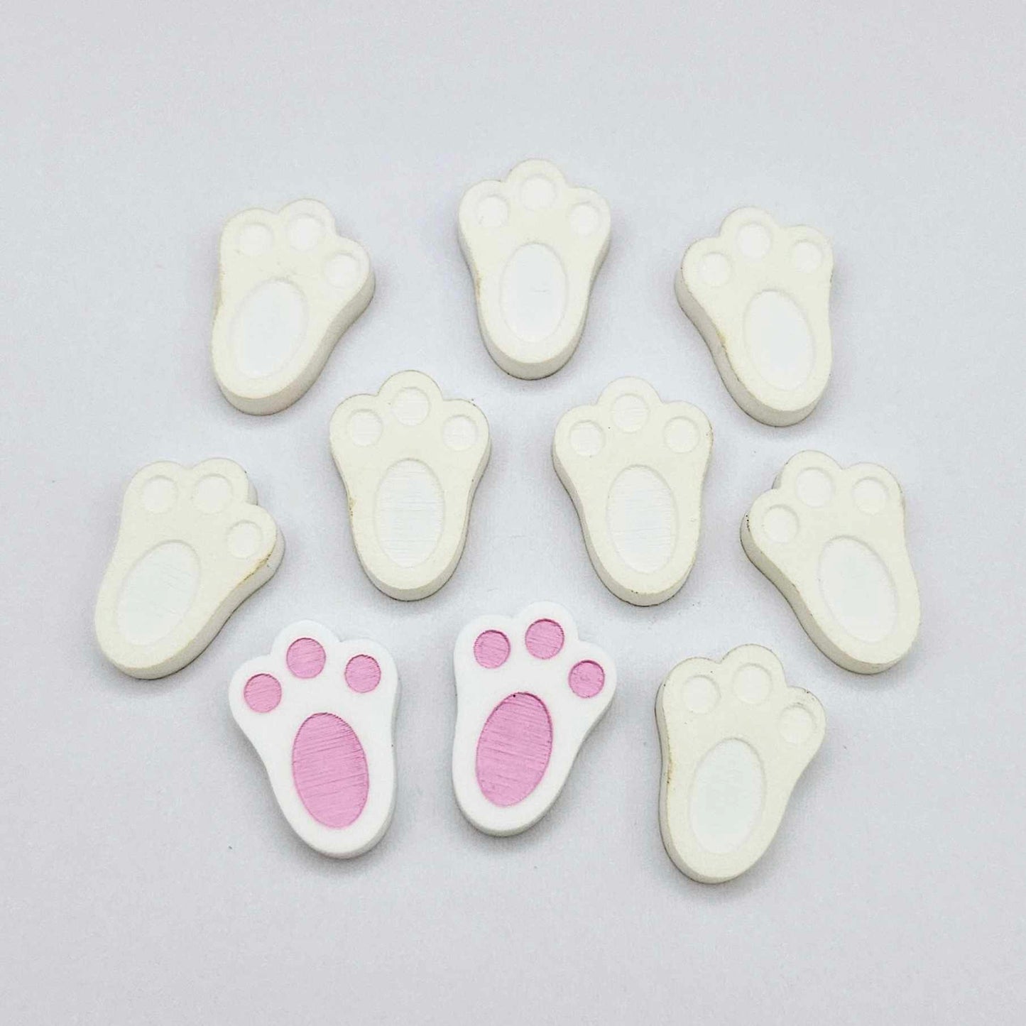 white bunny paw print stud blanks showing two paint filled pink and several unpainted pieces