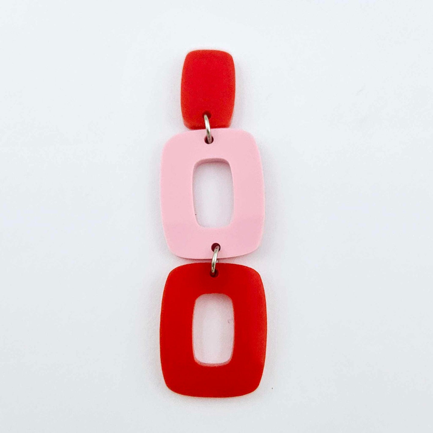 Assembled layered rectangle dangle earring in red and pastel pink acrylic, three-piece geometric statement design