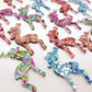 A selection of 45mm chunky glitter acrylic reindeer dangle earring blanks in Holographic Rose Gold, Chunky Love, Aqua, Peacock and Unicorn Glitter laying flat.