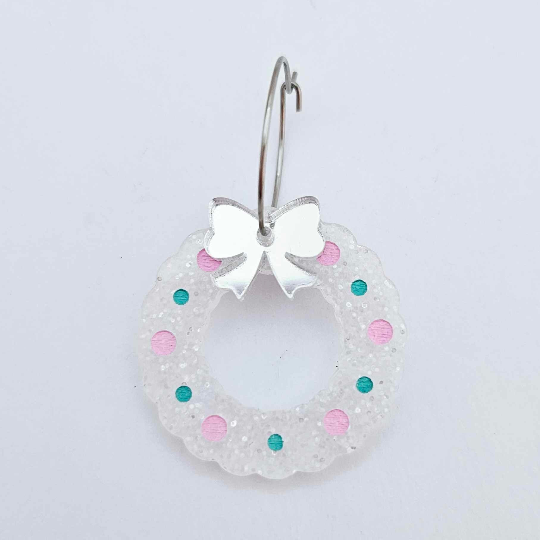 fairy dust glitter acrylic wreath earring blanks that have been paint filled with aqua green and lavender posca paint pens