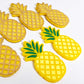 yellow acrylic pineapple earring blanks that have been paint filled with green and sunshine yellow posca paint pens