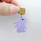 32mm pastel purple bunny dangle blanks showing paint filled black eyelashes hanging from 12mm oak wood square topper