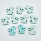 Pastel aqua bunny stud blanks showing finished paint filled black eyelashes on two studs, with the rest shown as supplied with protective film