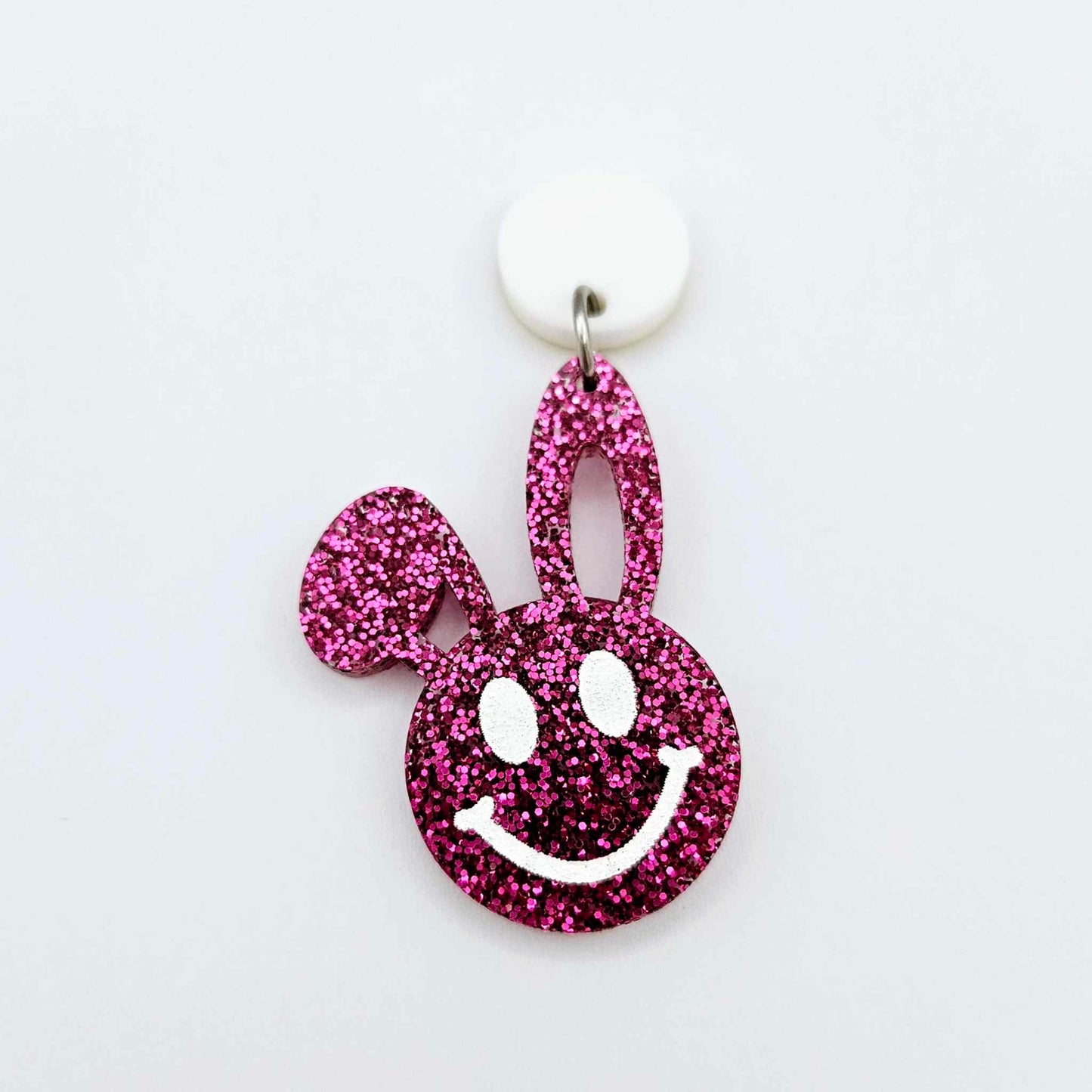 Hot pink glitter acrylic bunny dangle earring blank hanging from a 14mm white acrylic topper, bunny head with floppy ear and paint filled smiley face