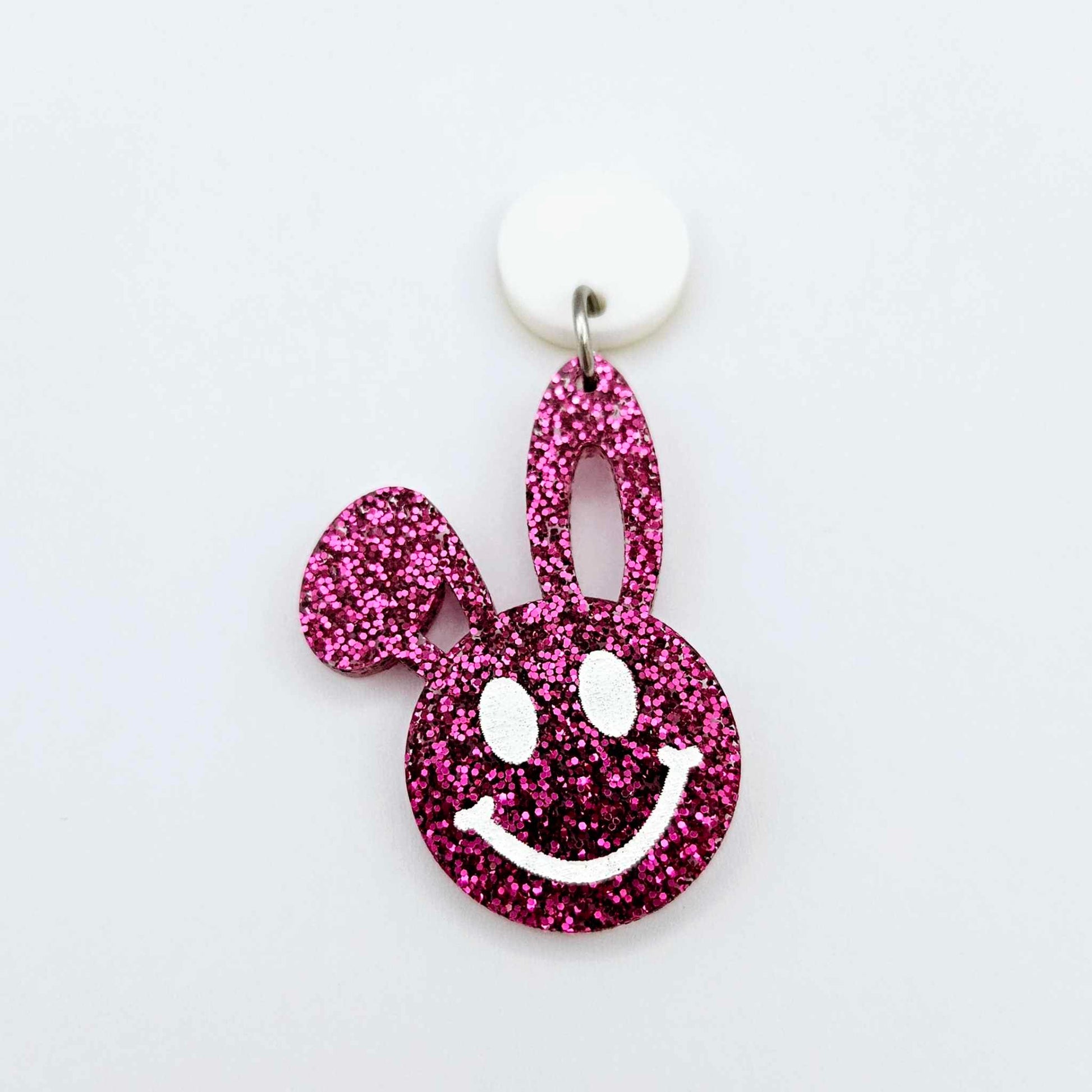 Hot pink glitter acrylic bunny dangle earring blank hanging from a 14mm white acrylic topper, bunny head with floppy ear and paint filled smiley face