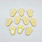 Pastel yellow bunny paw print stud blanks showing two paint filled white and several unpainted pieces