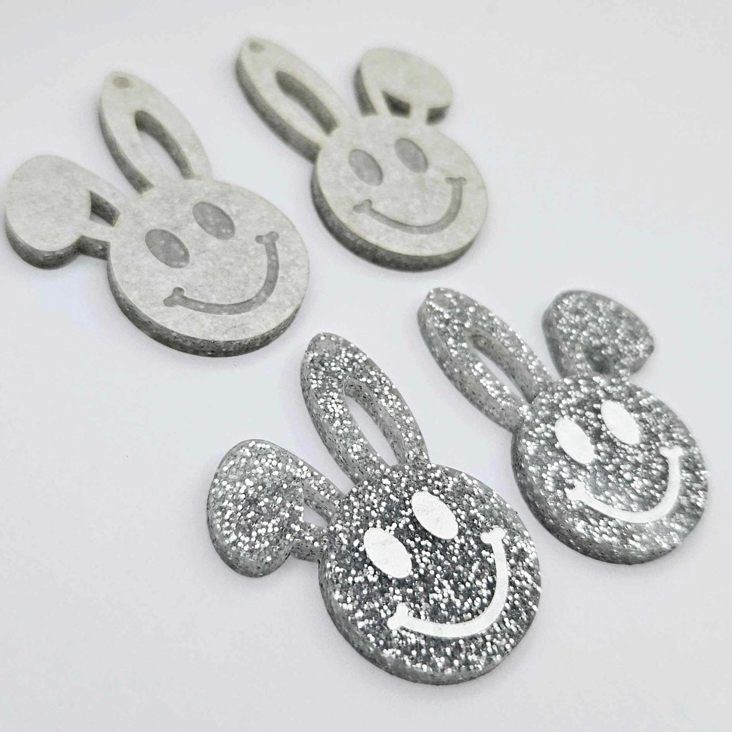 38mm silver glitter acrylic bunny dangle blanks with engraved smiley face, two paint filled white and two others unfilled with protective film on