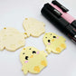 Pastel yellow acrylic chicken dangle blanks with engraved face and feet, two paint filled and two with protective film on, shown with Posca paint pens