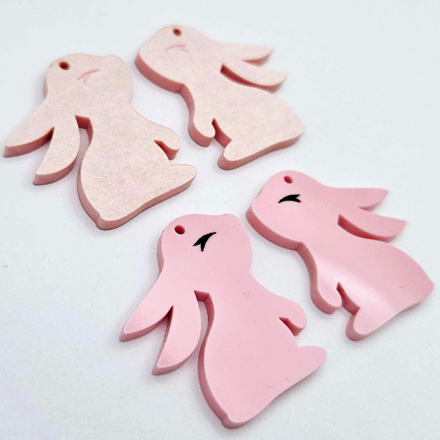 32mm Pastel pink bunny dangle blanks showing paint filled black eyelashes on two pieces, with remaining pieces shown with protective paper as supplied