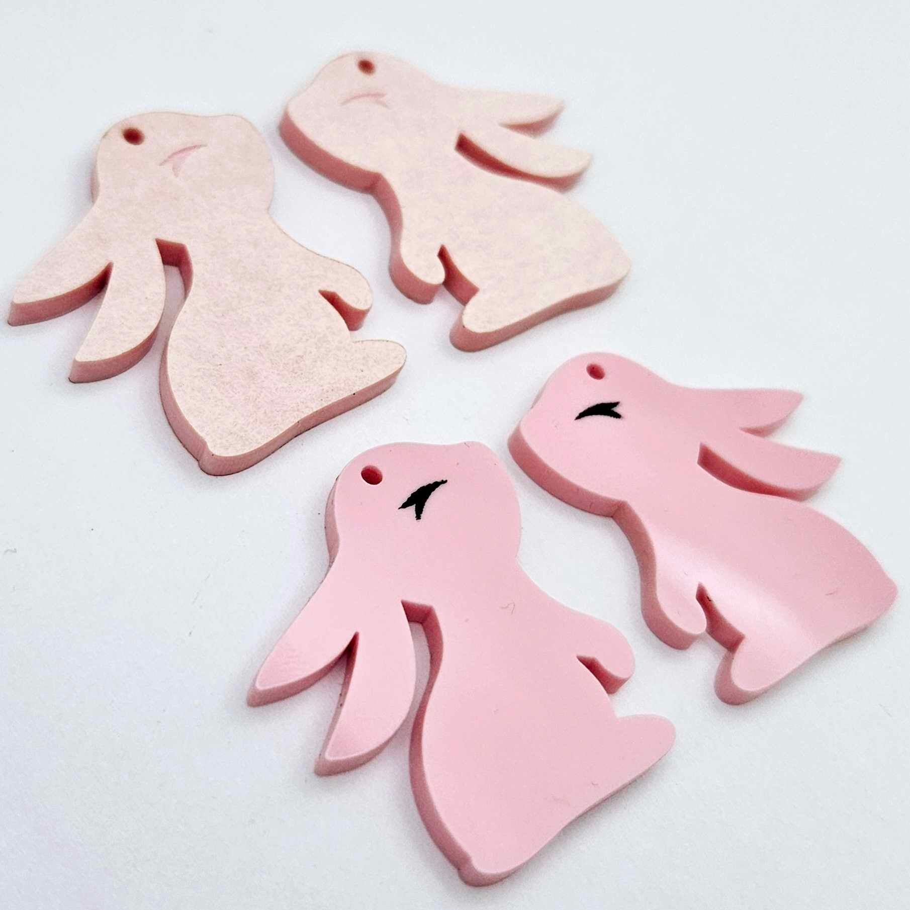 32mm Pastel pink bunny dangle blanks showing paint filled black eyelashes on two pieces, with remaining pieces shown with protective paper as supplied