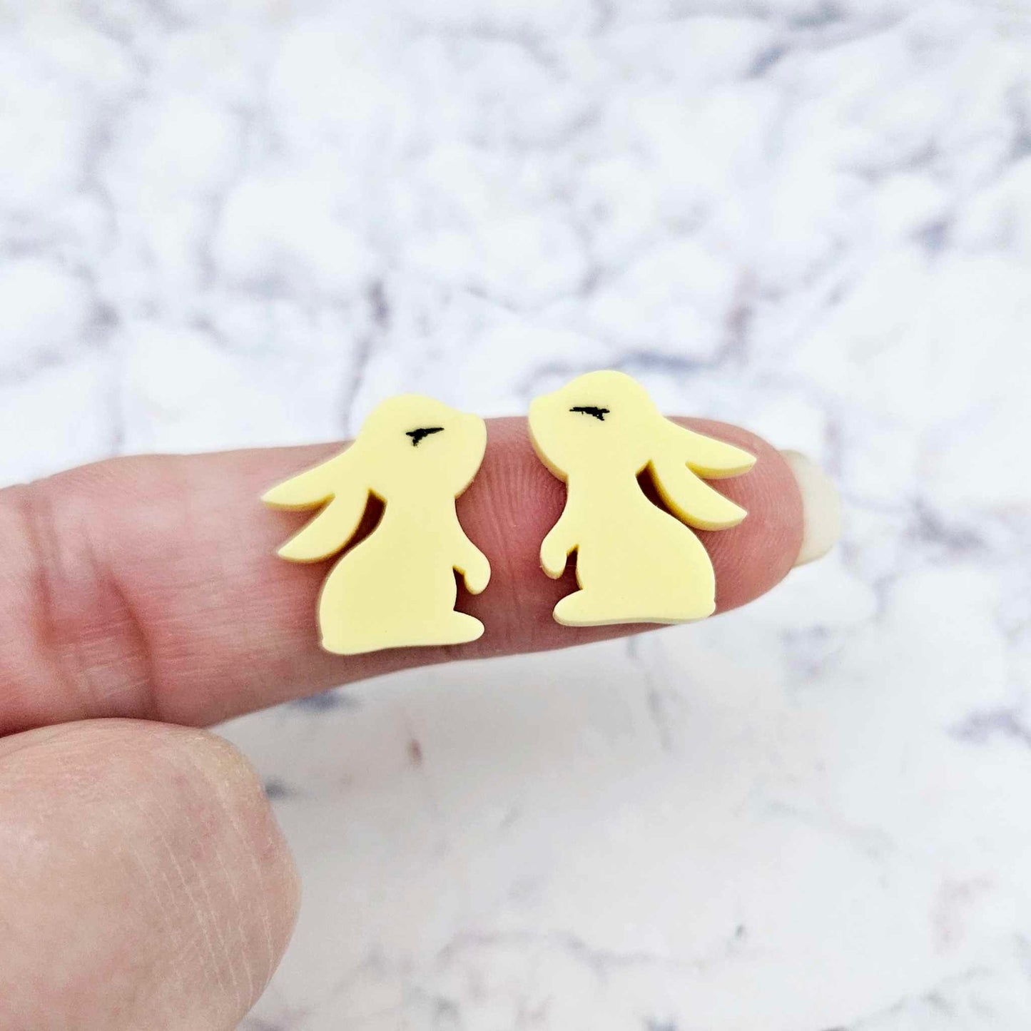 Close-up of pastel yellow acrylic bunny stud blanks with paint filled eyelashes