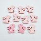 Pastel pink bunny stud blanks showing finished paint filled black eyelashes on two studs, with the rest shown as supplied with protective film