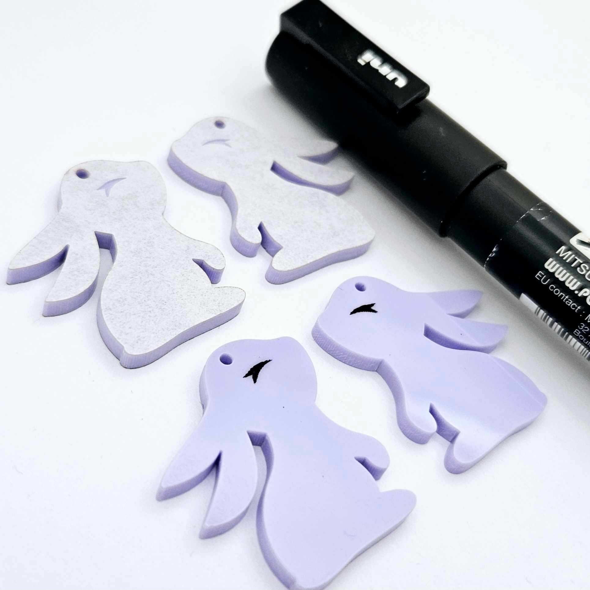 32mm pastel purple bunny dangle blanks showing paint filled black eyelashes on two pieces, with remaining pieces shown with protective paper as supplied