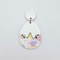 Assembled cracked egg acrylic dangle earring blank with white top and pastel pop UV printed bottom, hanging from a 14mm white earring topper