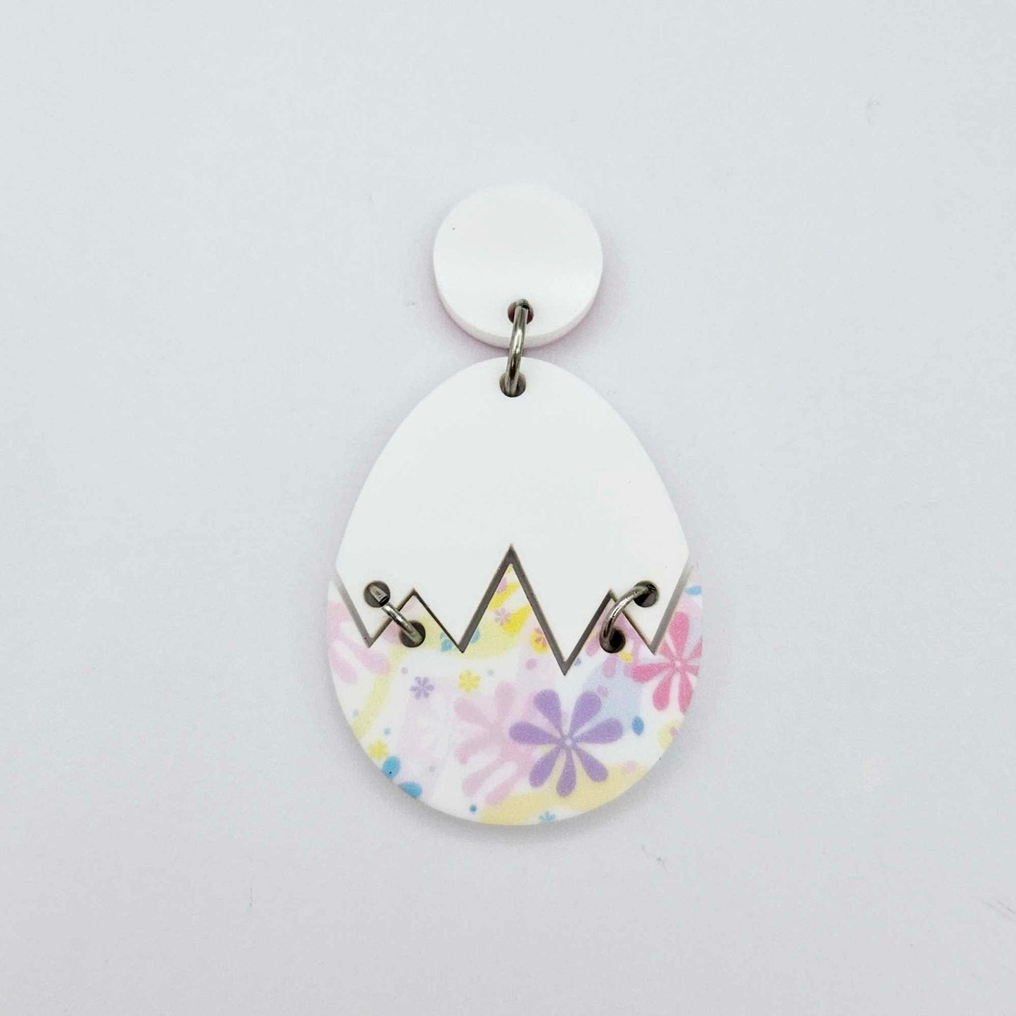 Assembled cracked egg acrylic dangle earring blank with white top and pastel pop UV printed bottom, hanging from a 14mm white earring topper