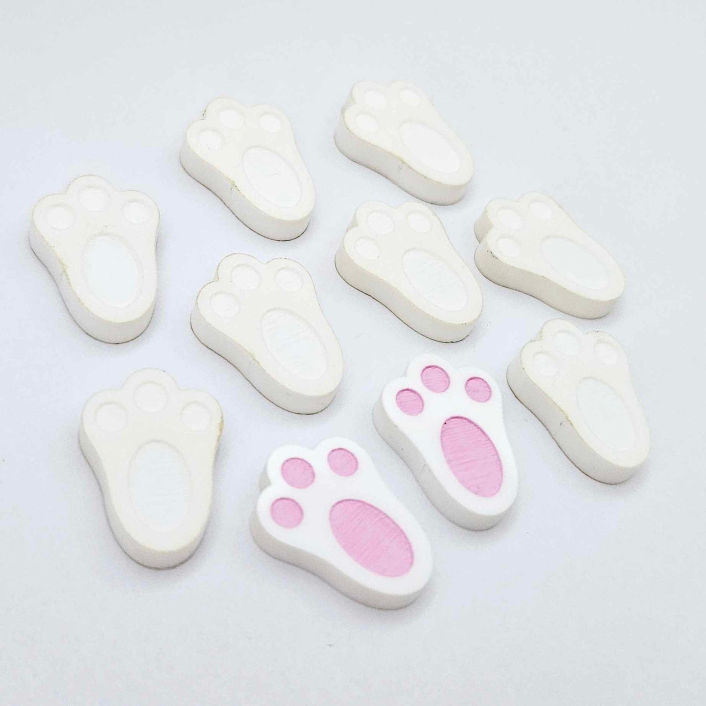 white bunny paw print stud blanks showing two paint filled pink and several unpainted pieces