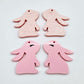 32mm Pastel pink bunny dangle blanks showing paint filled black eyelashes on two pieces, with remaining pieces shown with protective paper as supplied
