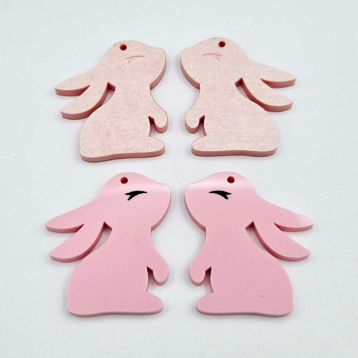 32mm Pastel pink bunny dangle blanks showing paint filled black eyelashes on two pieces, with remaining pieces shown with protective paper as supplied
