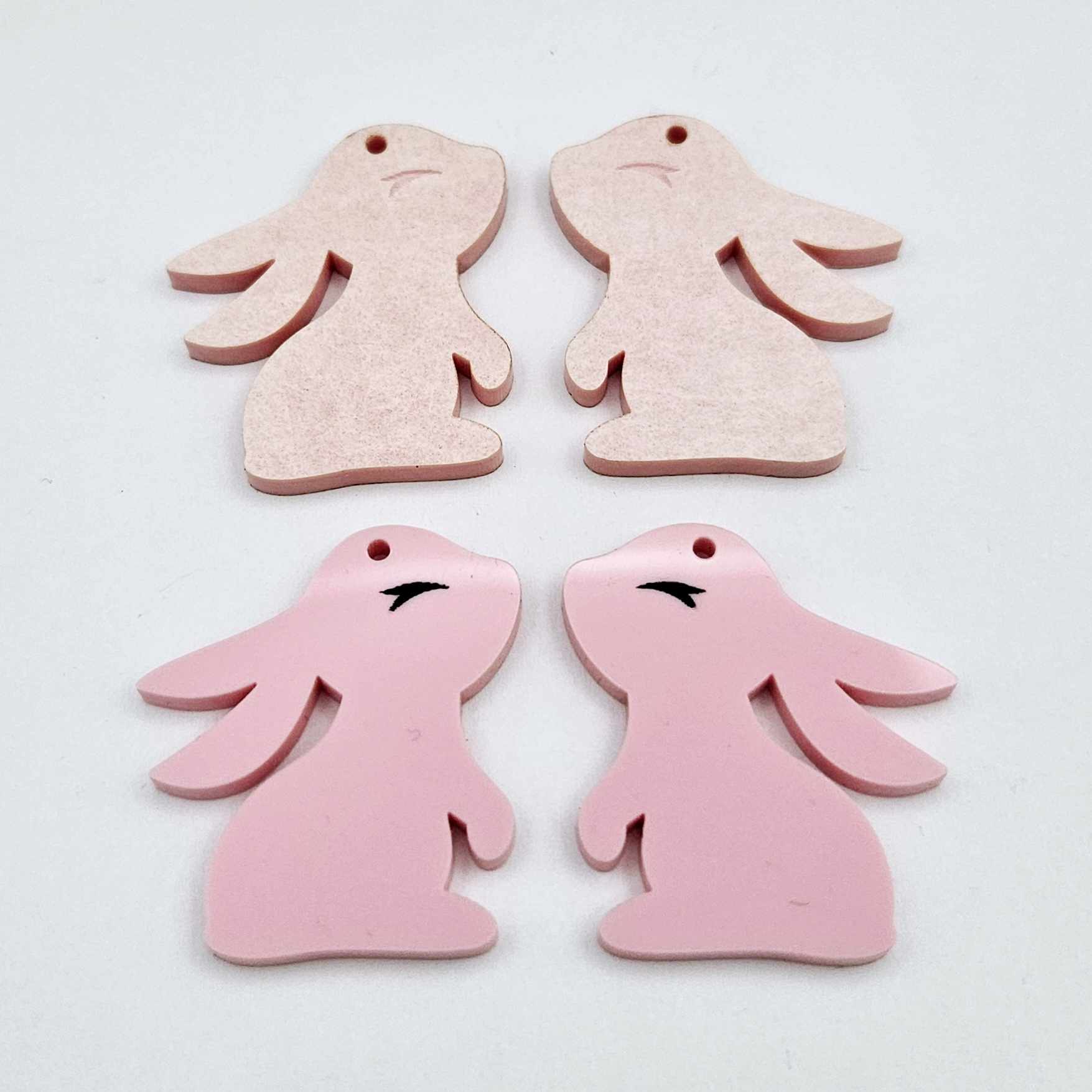 32mm Pastel pink bunny dangle blanks showing paint filled black eyelashes on two pieces, with remaining pieces shown with protective paper as supplied
