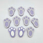 Pastel purple bunny paw print stud blanks showing two paint filled white and several unpainted pieces