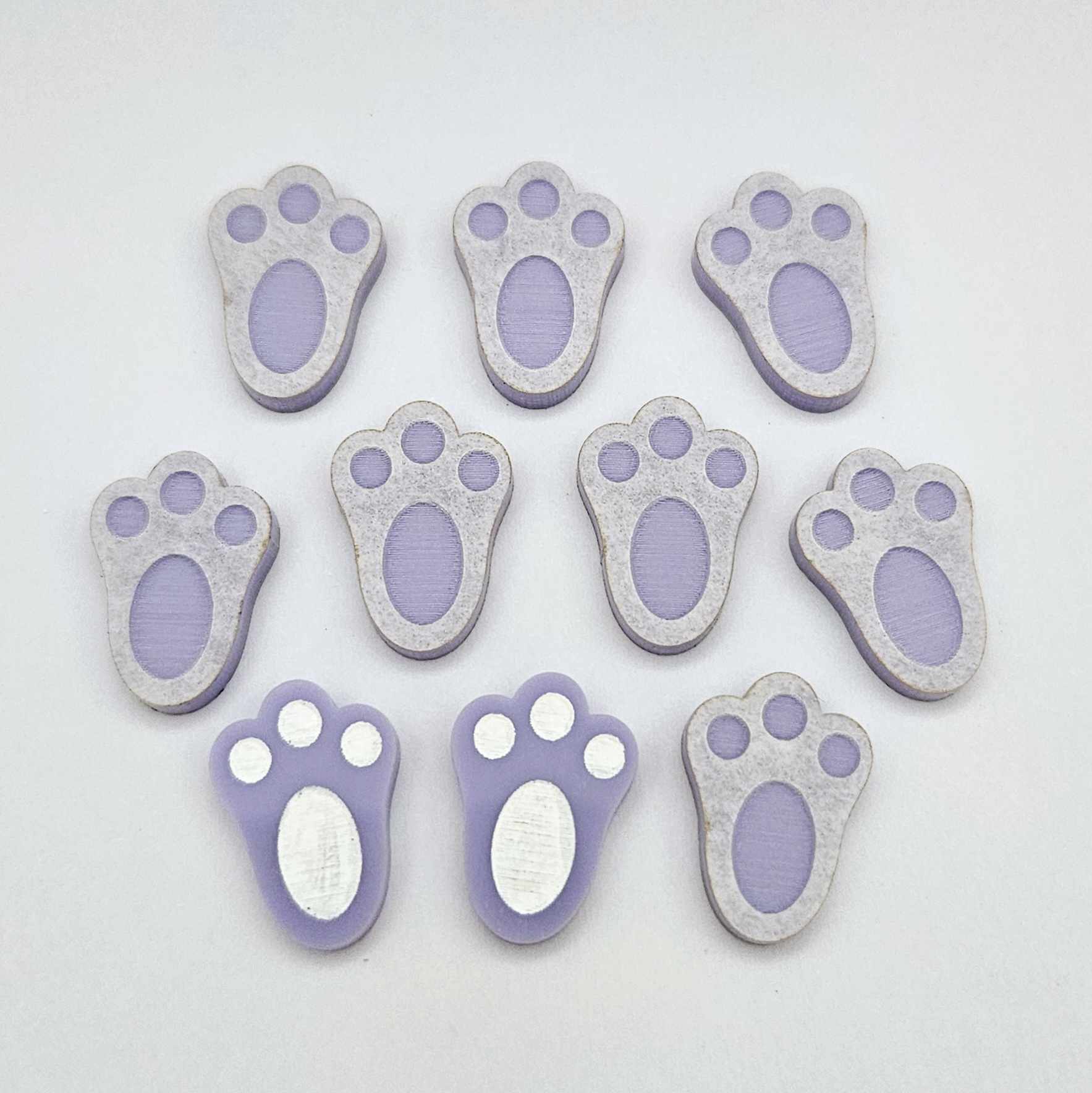 Pastel purple bunny paw print stud blanks showing two paint filled white and several unpainted pieces