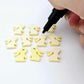 Pastel yellow bunny stud blanks showing finished paint filled black eyelashes on two studs, with the rest shown as supplied with protective film
