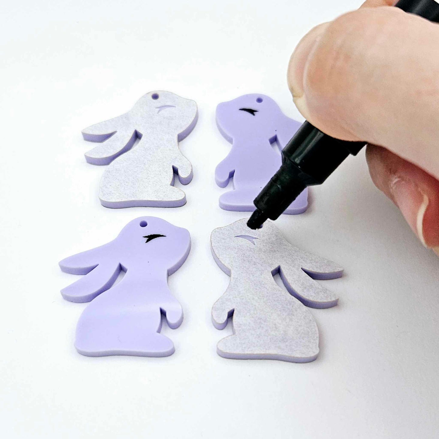 32mm pastel purple bunny dangle blanks showing paint filled black eyelashes on two pieces, with remaining pieces shown with protective paper as supplied