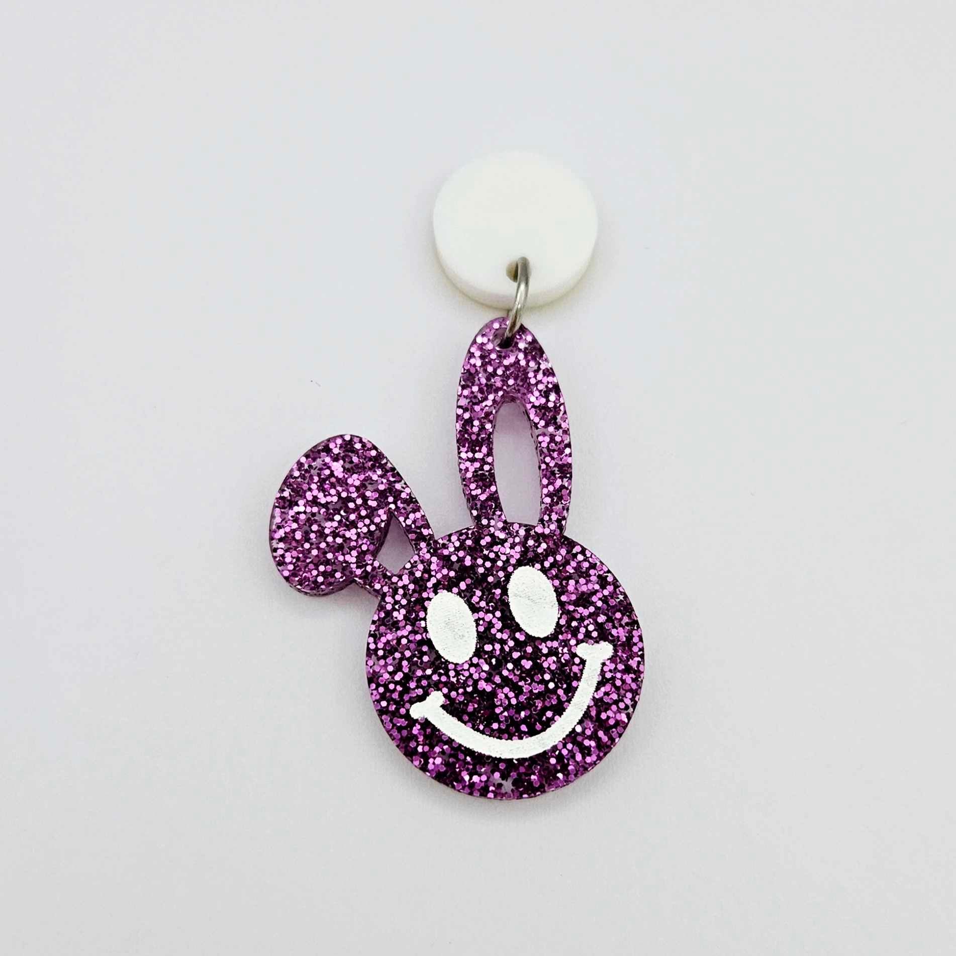38mm purple glitter acrylic bunny dangle earring blank hanging from a 14mm white acrylic topper, bunny head with floppy ear and paint filled smiley face