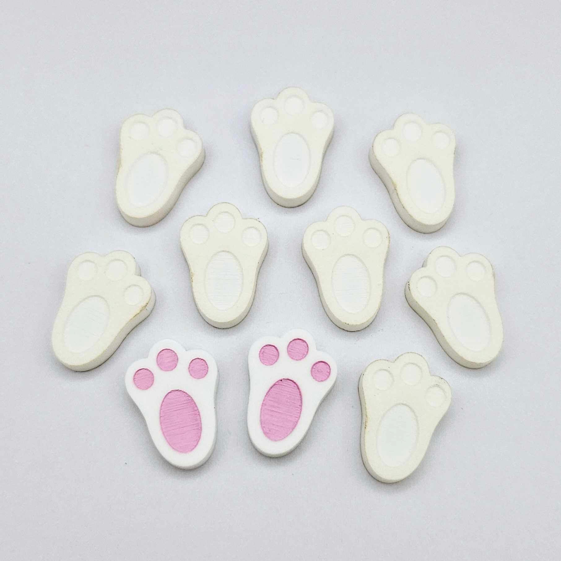 white bunny paw print stud blanks showing two paint filled pink and several unpainted pieces
