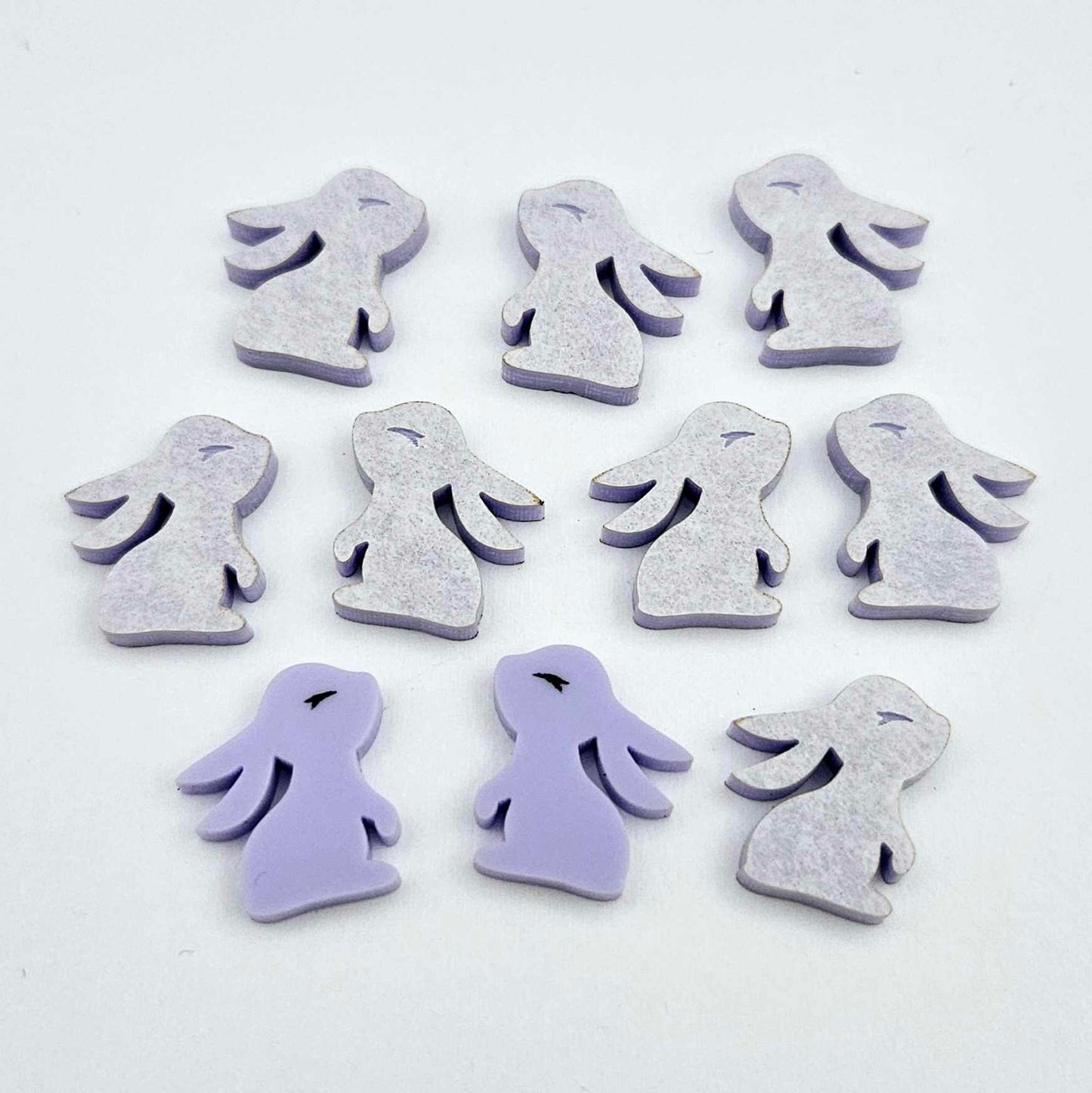 Pastel purple bunny stud blanks showing finished paint filled black eyelashes on two studs, with the rest shown as supplied with protective film
