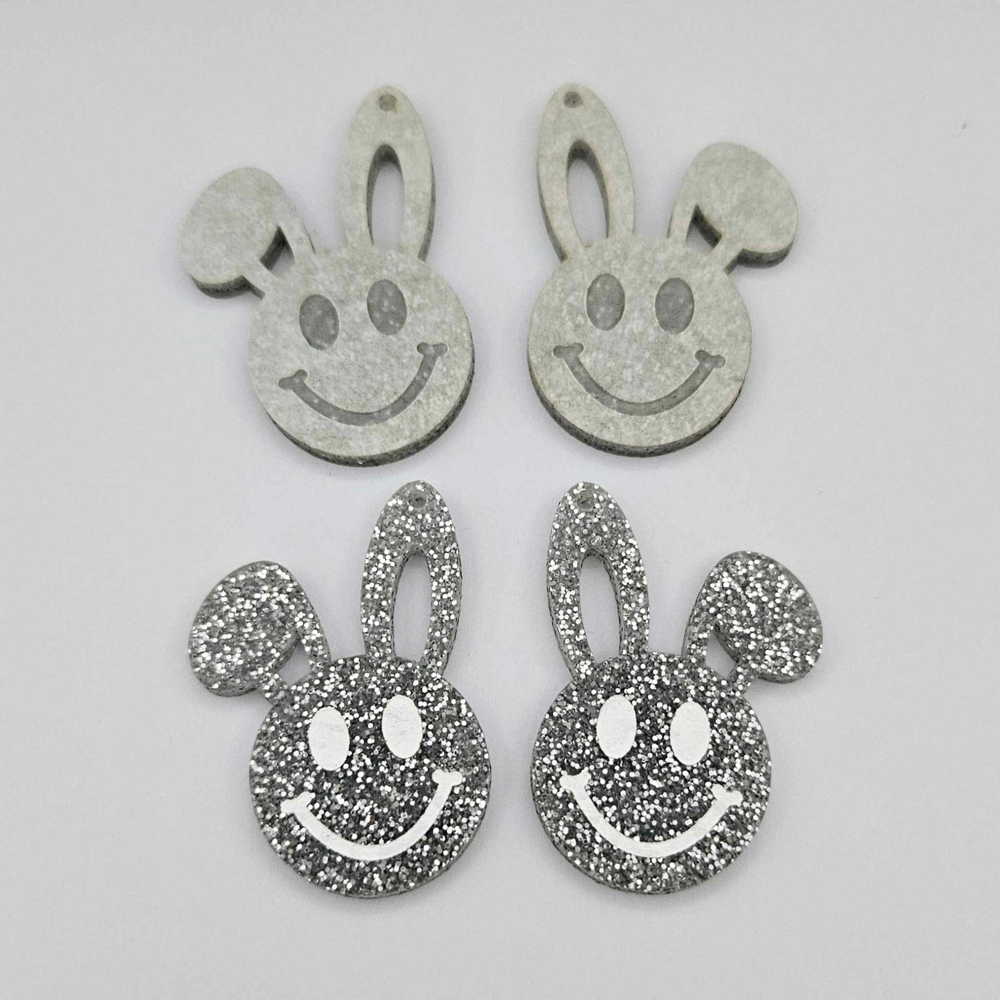 38mm silver glitter acrylic bunny dangle blanks with engraved smiley face, two paint filled white and two others unfilled with protective film on