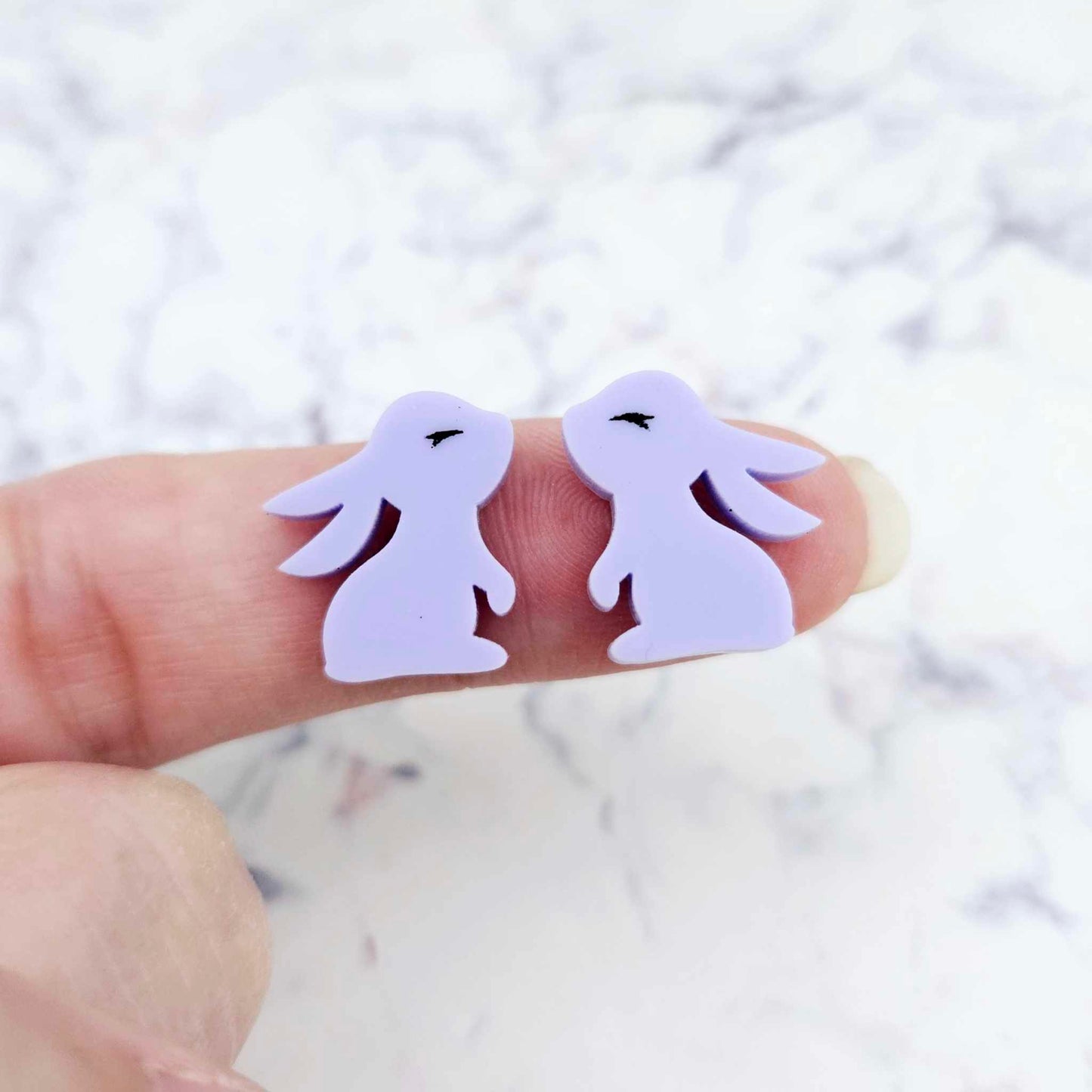 Close-up of pastel purple acrylic bunny stud blanks with paint filled eyelashes