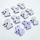 Pastel purple bunny stud blanks showing finished paint filled black eyelashes on two studs, with the rest shown as supplied with protective film