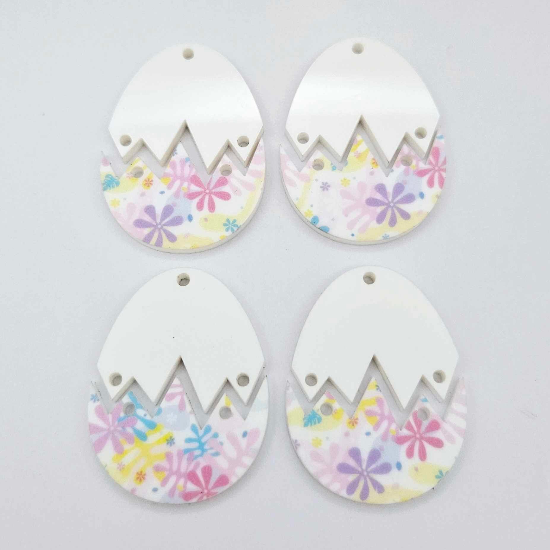 Four cracked egg earring blanks unassembled, white top halves and pastel pop UV printed bottom halves