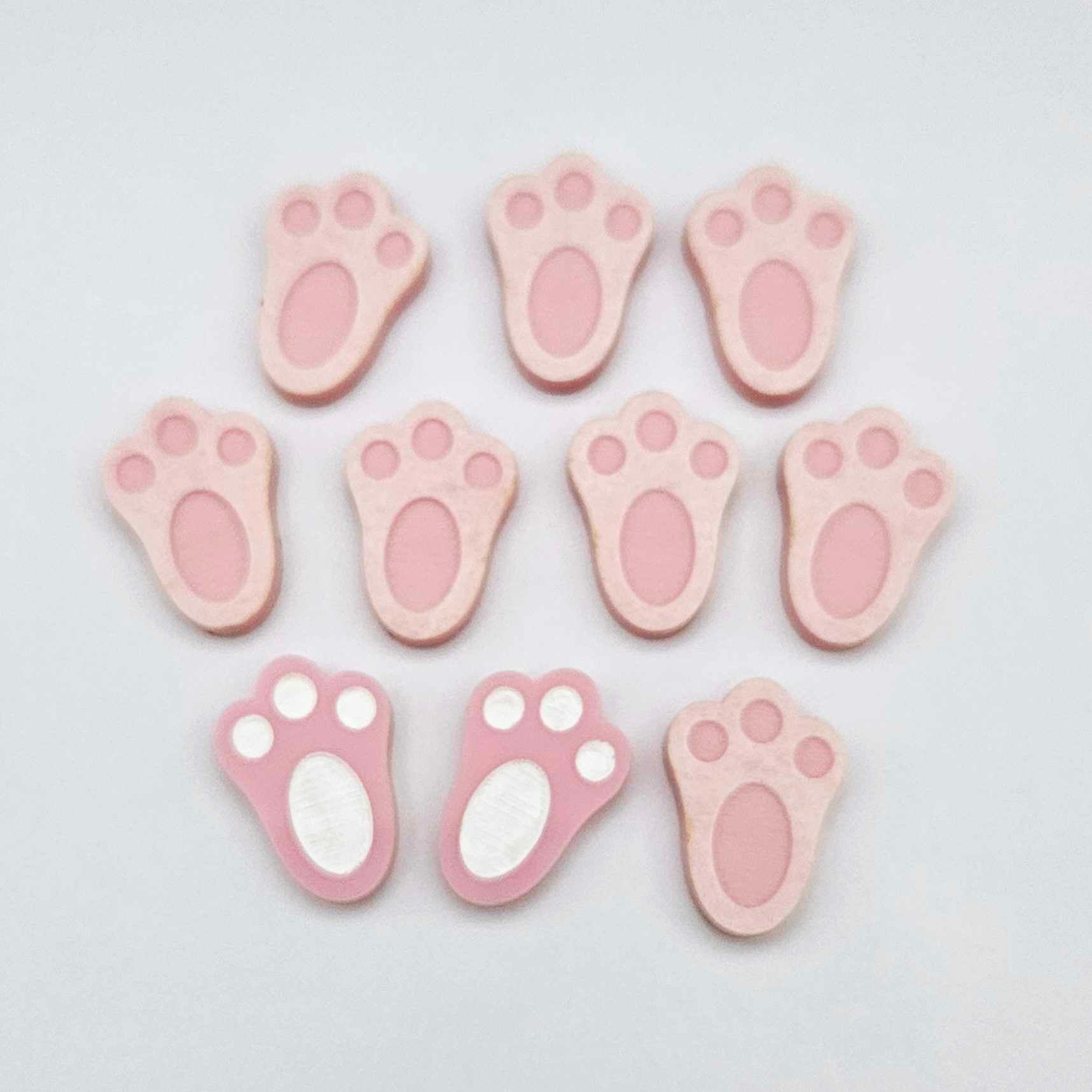 Pastel pink bunny paw print stud blanks showing two paint filled white and several unpainted pieces