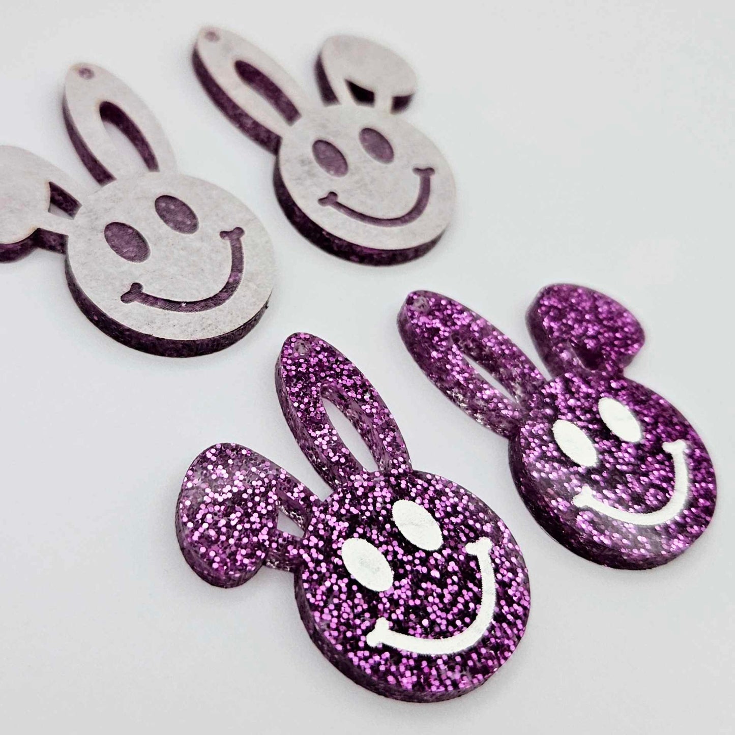38mm purple glitter acrylic bunny dangle blanks with engraved smiley face, two paint filled white and two others unfilled with protective film on