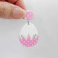 Assembled cracked egg dangle earring blank with white top and pastel pink polka dot UV printed bottom, hanging from a 14mm pink polka dot earring topper