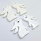 32mm white bunny dangle blanks showing paint filled black eyelashes on two pieces, with remaining pieces shown with protective paper as supplied
