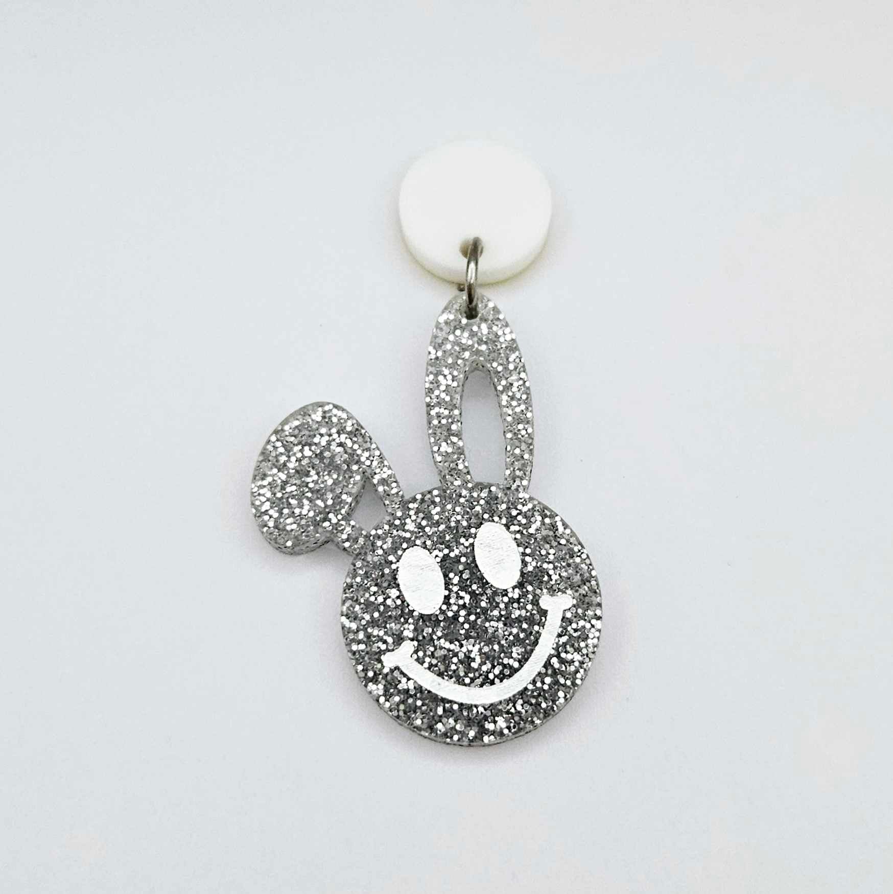 38mm silver glitter acrylic bunny dangle earring blank hanging from a 14mm white acrylic topper, bunny head with floppy ear and paint filled smiley face