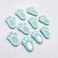 Pastel aqua bunny paw print stud blanks showing two paint filled white and several unpainted pieces