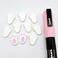 white bunny paw print stud blanks showing two paint filled pink and several unpainted pieces, with a Light Pink Posca paint pen included in the image