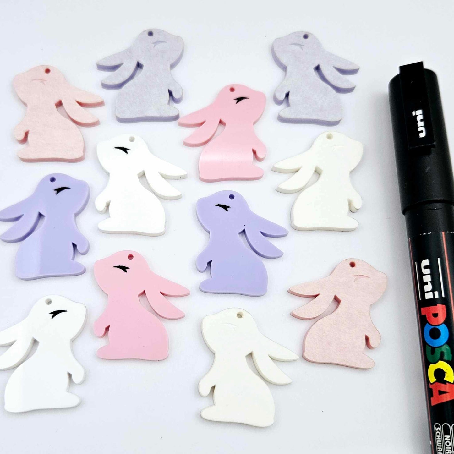 32mm pastel pink, pastel purple and white bunny dangle blanks mixed pack showing paint filled black eyelashes, with remaining pieces shown with protective paper as supplied