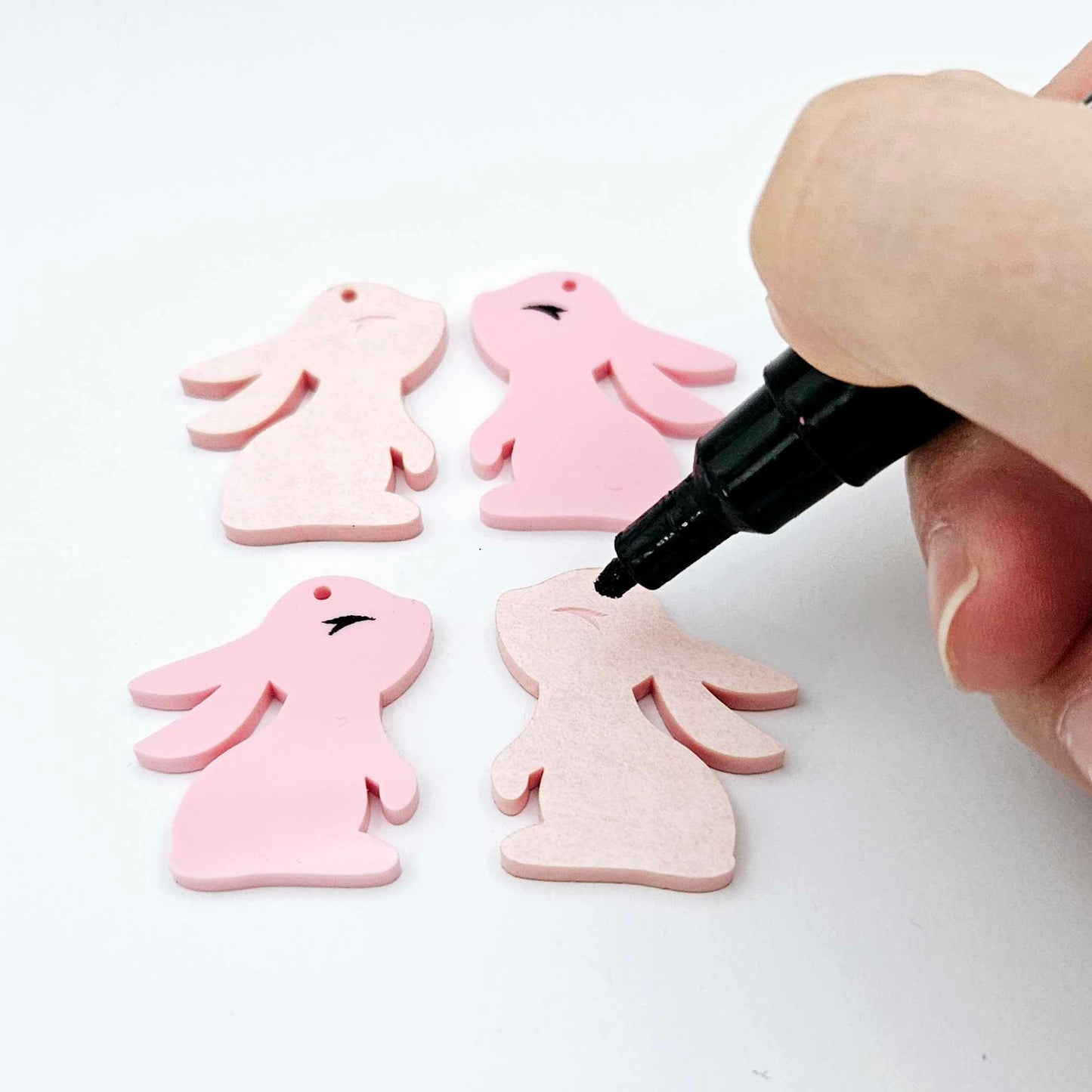 32mm Pastel pink bunny dangle blanks showing paint filled black eyelashes on two pieces, with remaining pieces shown with protective paper as supplied