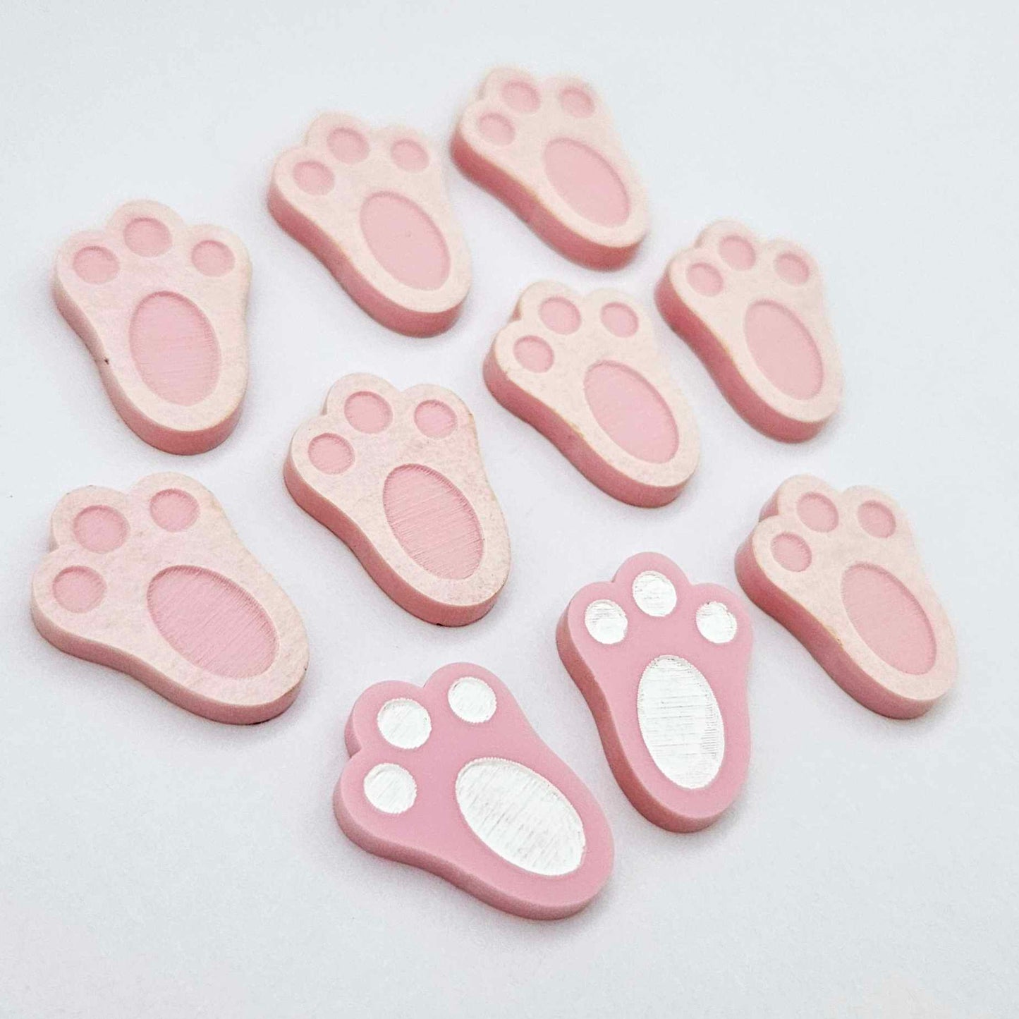 Pastel pink bunny paw print stud blanks showing two paint filled white and several unpainted pieces