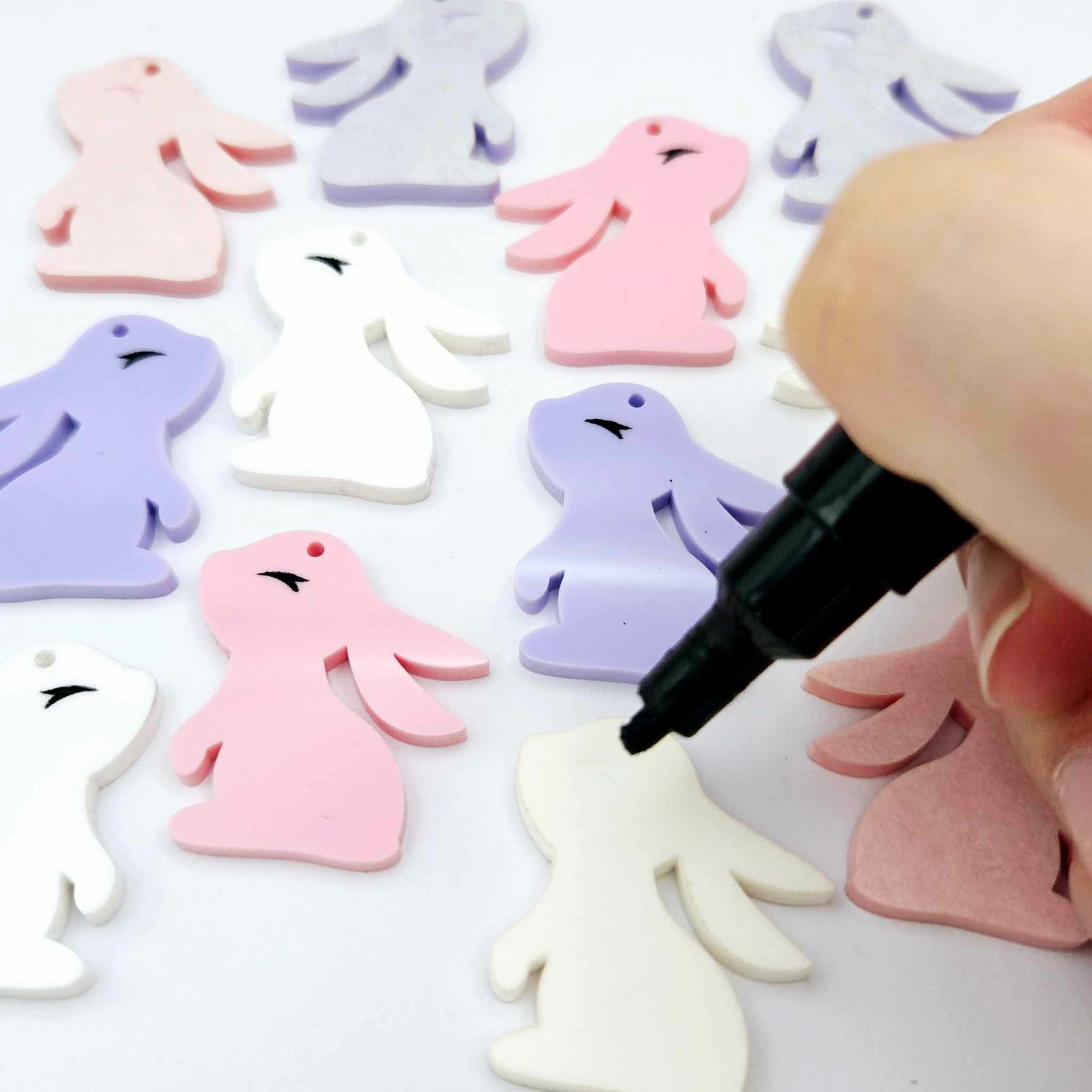 32mm pastel pink, pastel purple and white bunny dangle blanks mixed pack showing paint filled black eyelashes, with remaining pieces shown with protective paper as supplied