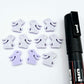 Pastel purple bunny stud blanks showing finished paint filled black eyelashes on two studs, with the rest shown as supplied with protective film
