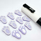 Pastel purple bunny paw print stud blanks showing two paint filled white and several unpainted pieces, with a white Posca paint pen included in the image