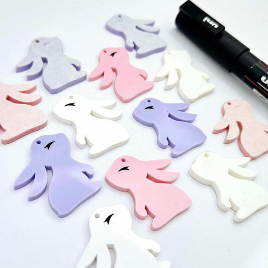 32mm pastel pink, pastel purple and white bunny dangle blanks mixed pack showing paint filled black eyelashes, with remaining pieces shown with protective paper as supplied