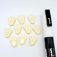 Pastel yellow bunny paw print stud blanks showing two paint filled white and several unpainted pieces, with a white Posca paint pen included in the image